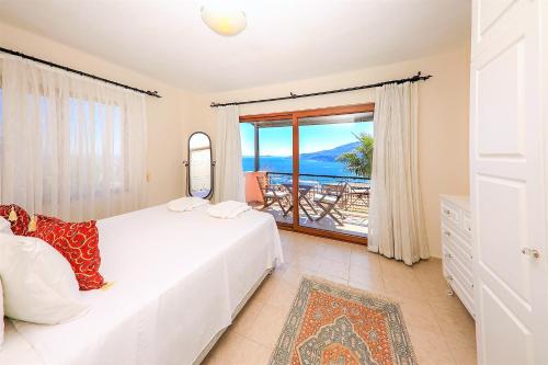 a bedroom with a bed and a view of the ocean at Villa Tymnessos in Kalkan