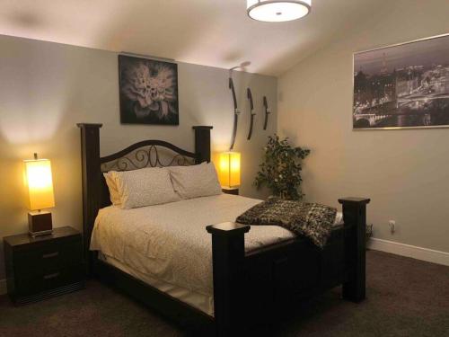 a bedroom with a large bed with two lamps on it at Cheerful and beautiful 3 bedroom home close lake in Edmonton