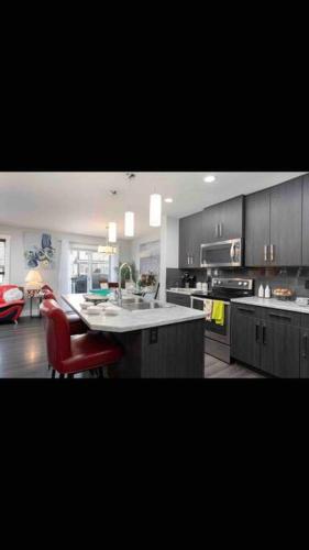 a kitchen with a counter and a red chair in it at Cheerful and beautiful 3 bedroom home close lake in Edmonton