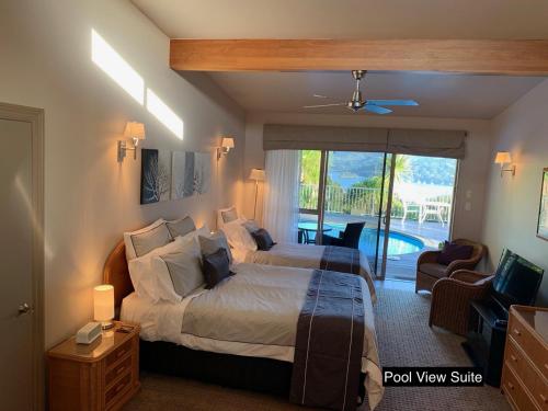 a bedroom with a bed and a view of a pool at King's View Lodge in Whangaroa