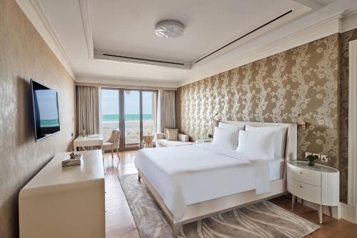 una camera d'albergo con letto e TV di Club Privé By Rixos Saadiyat a Abu Dhabi
