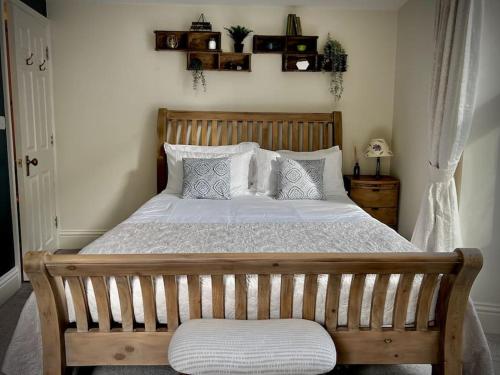 1 dormitorio con 1 cama grande con marco de madera en Period apartment, great views, in heart of town., en Bradford on Avon