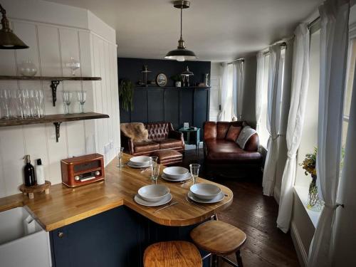 una sala de estar con una mesa con platos. en Period apartment, great views, in heart of town., en Bradford on Avon