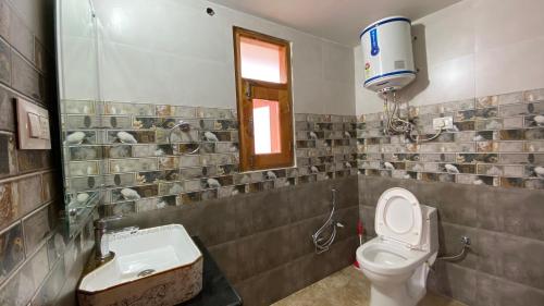 uma casa de banho com um WC e um lavatório em Kavya Home Stay em Chachyot