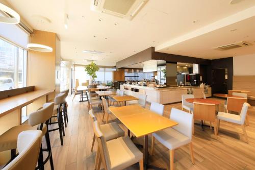 a restaurant with tables and chairs and a kitchen at Richmond Hotel Nagoya Shinkansen-guchi in Nagoya