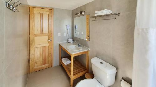 a bathroom with a toilet and a sink and a mirror at Paradise Beachfront & Nightlife Heart in Cancún