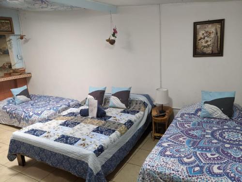 1 dormitorio con 2 camas y mesa con lámpara en Guesthouse Casa Lapa2, en Alajuela