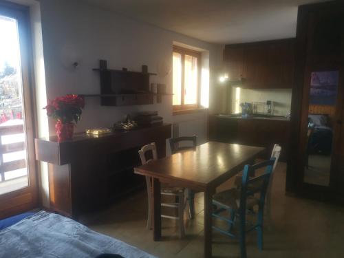 een keuken en eetkamer met een tafel en stoelen bij BAITA DEL SOLE in Teglio