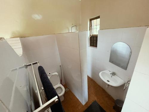 a bathroom with a toilet and a sink at Maktau Mountain Lodge in Kirongo