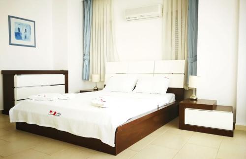 - une chambre avec un grand lit et des draps blancs dans l'établissement Pleasant, à Belek