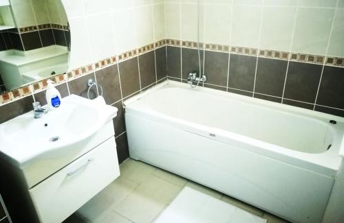 ein Badezimmer mit einer weißen Badewanne und einem Waschbecken in der Unterkunft Pleasant in Belek