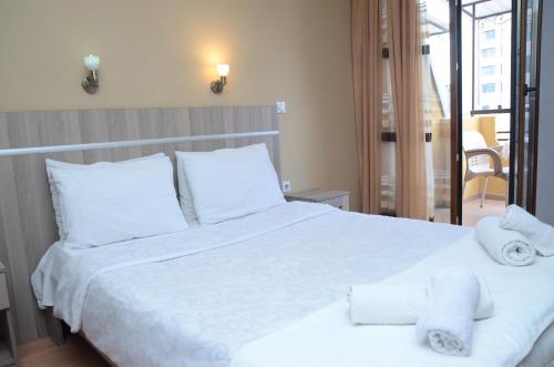 a bedroom with a white bed with towels on it at Villa Konzuli in Bitola