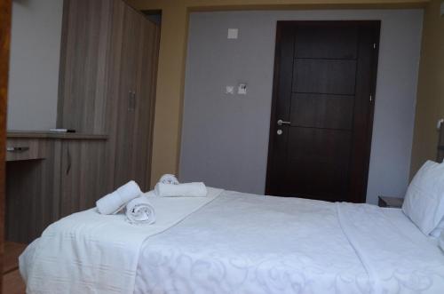 a hotel room with a white bed with towels on it at Villa Konzuli in Bitola