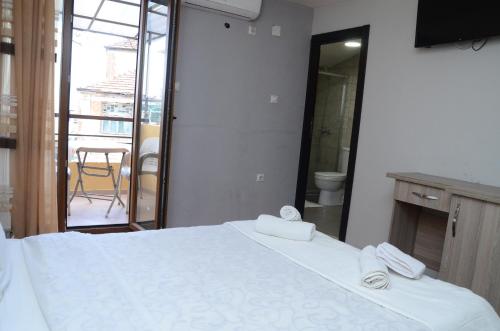 a bedroom with a white bed with towels on it at Villa Konzuli in Bitola