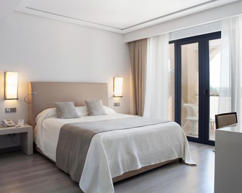 
a hotel room with a bed and a dresser at Hotel AR Golf Almerimar in Almerimar

