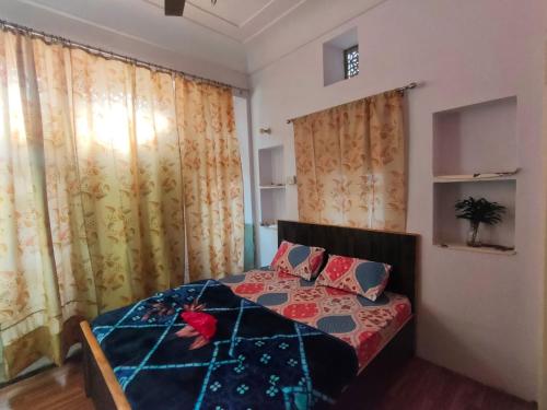 - une chambre avec un lit dans une chambre avec des rideaux dans l'établissement Friend India, à Jaipur
