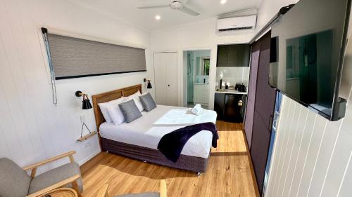 a bedroom with a bed and a television in it at Poinciana at Cooee Bay in Yeppoon