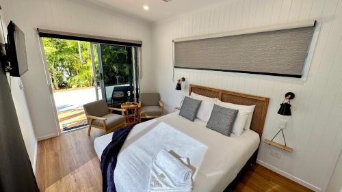 a bedroom with a bed and a large window at Poinciana at Cooee Bay in Yeppoon