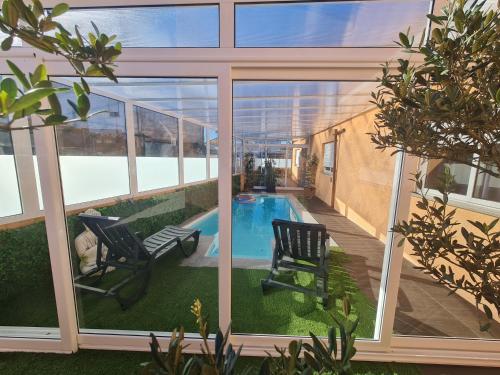a courtyard with two chairs and a swimming pool at Casa Particular das Pedras in Vila Nova de Gaia