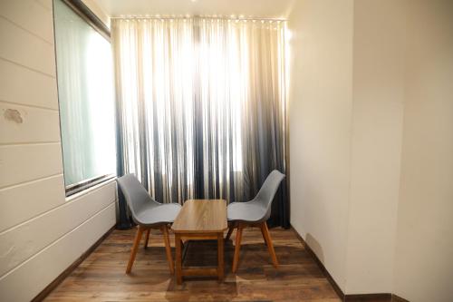 uma mesa e duas cadeiras num quarto com uma janela em Hotel Sudarshan Palace em Lātūr