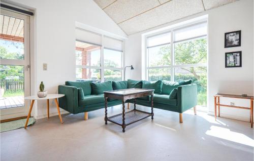 a living room with a green couch and a table at Eight-Bedroom Holiday Home In Glesborg in Glesborg
