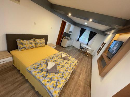 sypialnia z żółtym łóżkiem i telewizorem w obiekcie Studio apartment Lalović w mieście Žabljak