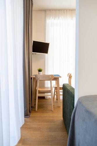 a table and chair in a room with a window at COME2rest - Kalno namai in Juodkrantė