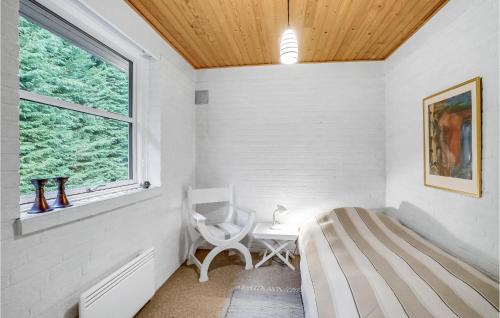 1 dormitorio con cama, ventana y silla en Amazing Home In Hjslev With Kitchen, en Højslev