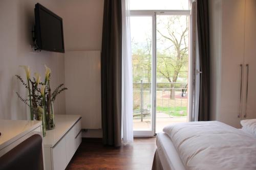 a bedroom with a bed and a sliding glass door at Hotel Restaurant Schwan in Wertheim