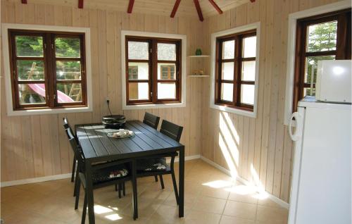 a kitchen with a table and a refrigerator at Three-Bedroom Holiday Home In Bagenkop in Bagenkop