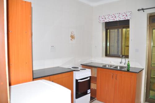 a small kitchen with a sink and a stove at Signature Hotel Apartments in Jinja