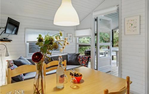 a dining room with a table with a bottle of wine at 2 Bedroom Amazing Home In Nexø in Neksø