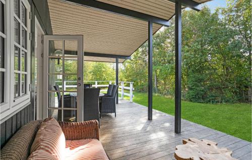 a covered deck with a couch on a house at Gorgeous Home In Vejby With Wifi in Vejby