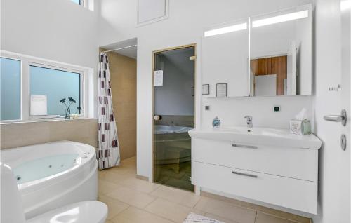 een witte badkamer met een bad en een wastafel bij Amazing Home In Haderslev With Sauna in Årøsund