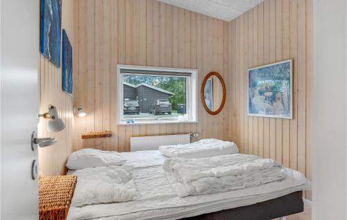 Amazing Home In Haderslev With Sauna في Årøsund: غرفة نوم بسرير وملاءات بيضاء ونافذة