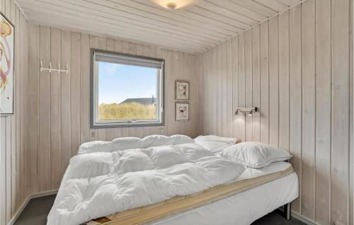 SønderhoにあるNice Home In Fan With 3 Bedrooms And Wifiの窓付きの客室の大型ベッド1台分です。