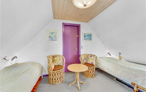 NymindegabにあるGorgeous Home In Nrre Nebel With Kitchenのベッドルーム1室(ベッド2台、テーブル、椅子付)