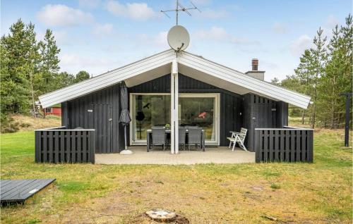 um barracão preto com um telhado branco e uma mesa em Cozy Home In Rm With Kitchen em Bolilmark