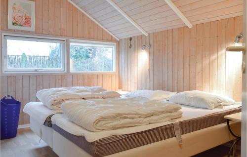 DronningmølleにあるAwesome Home In Dronningmlle With 4 Bedrooms, Sauna And Wifiの木製の壁の客室の大型ベッド1台