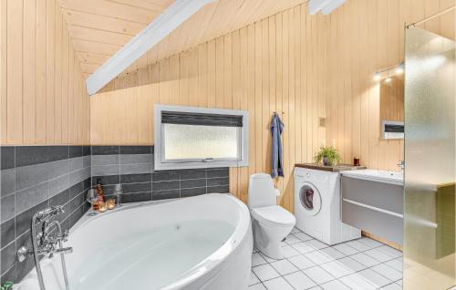 uma casa de banho com uma banheira, um WC e um lavatório. em 3 Bedroom Nice Home In Hvide Sande em Bjerregård
