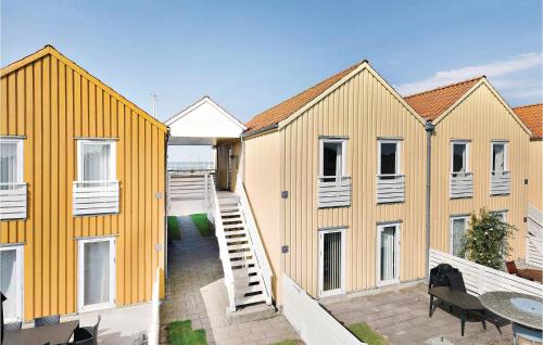 a row of yellow houses with a patio at Two-Bedroom Apartment In Rudkobing in Rudkøbing