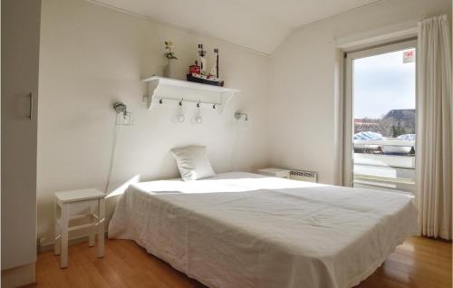 a white bedroom with a bed and a window at Two-Bedroom Apartment In Rudkobing in Rudkøbing