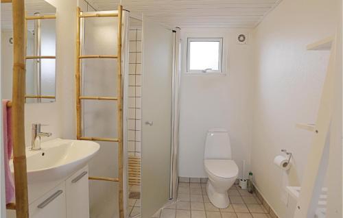 a bathroom with a toilet and a sink at Cozy Home In stermarie With Kitchen in Østermarie