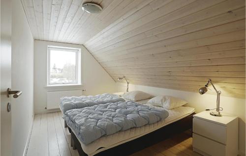Cama grande en habitación con techo de madera en Cozy Home In stermarie With Kitchen, en Østermarie