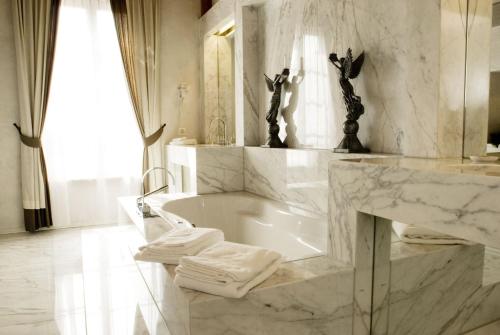 La salle de bains blanche est pourvue d'une baignoire et d'un lavabo. dans l'établissement Romantik Hotel Landhaus Liebefeld, à Berne