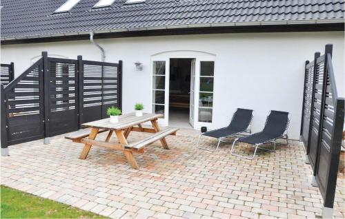 a patio with a wooden picnic table and two chairs at Sjørupgaard in Nimtofte