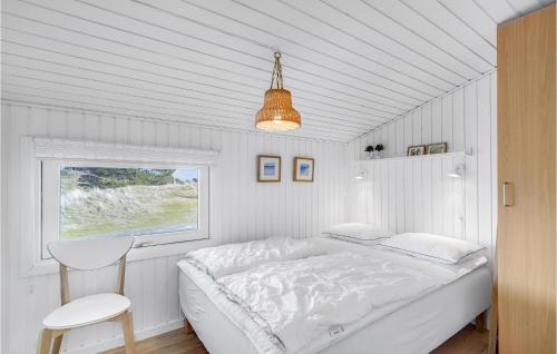 een witte slaapkamer met een bed en een raam bij Stunning Home In Fan With House A Panoramic View in Fanø