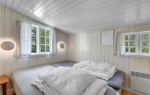 NeksøにあるMosehyttenの窓2つ付きの小さな部屋のベッド1台分です。