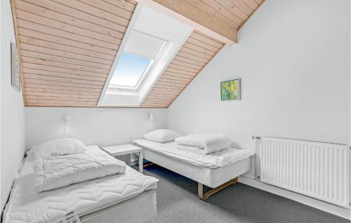 twee bedden in een kamer met een dakraam bij Rim Rm in Sønderby