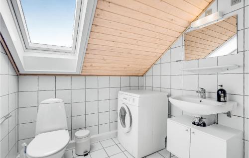 uma casa de banho com uma máquina de lavar roupa e um lavatório em Rim Rm em Sønderby